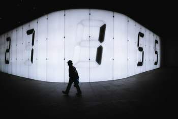 Image of person walking in front of numbers
