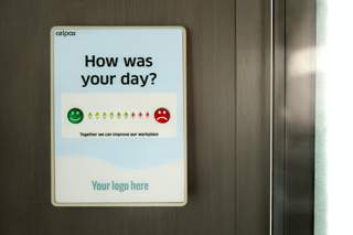 a sign asking how your day is with the option of green smiles or red frowns