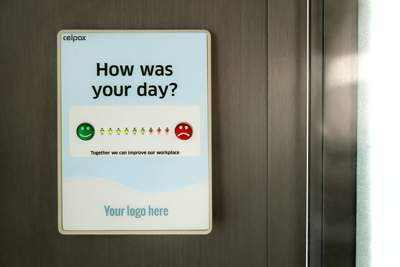 a sign asking how your day is with the option of green smiles or red frowns