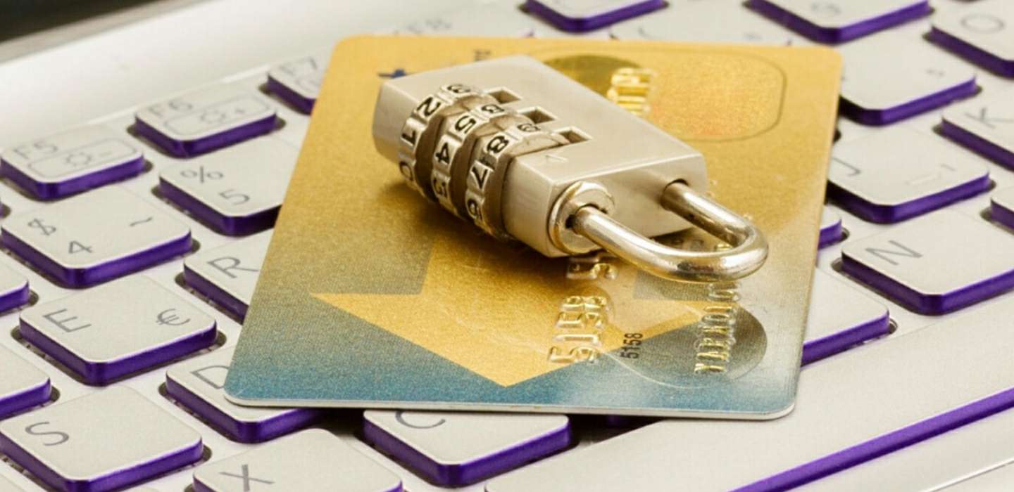 Photograph of a credit card and a combination lock placed on a keyboard